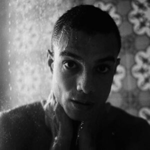 Man looking at camera in shower black and white