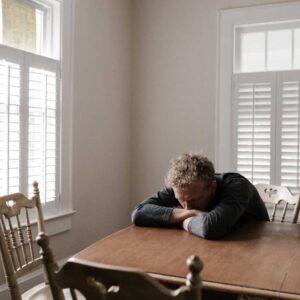 man with his head down and arms crossed with his head down