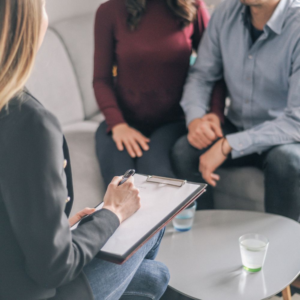 Couple holding hands in counseling session with therapist