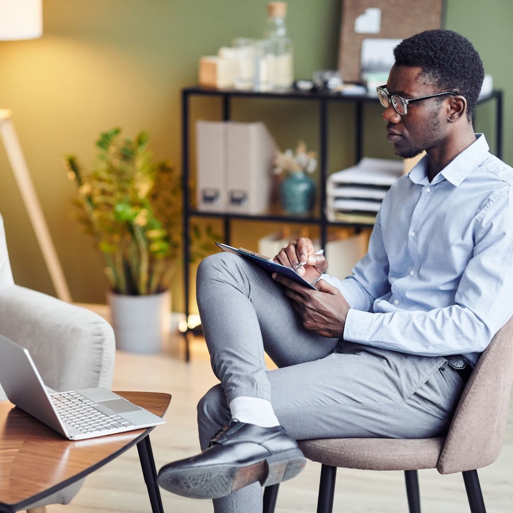 Focused therapist takes notes during insightful online therapy session