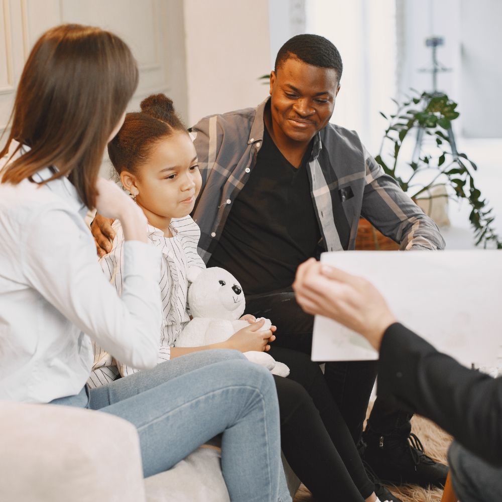 Child and parents engaged in supportive family counseling session