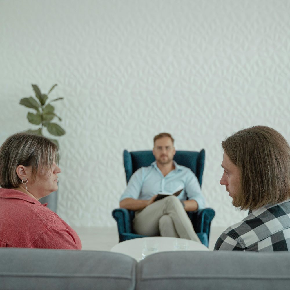 Therapist observes quietly as couple talks