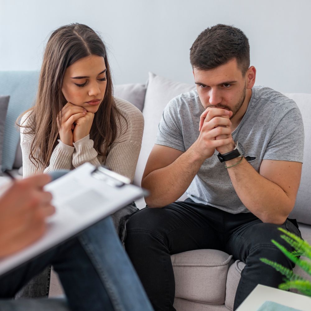 Couple looking tense during therapy session discussion