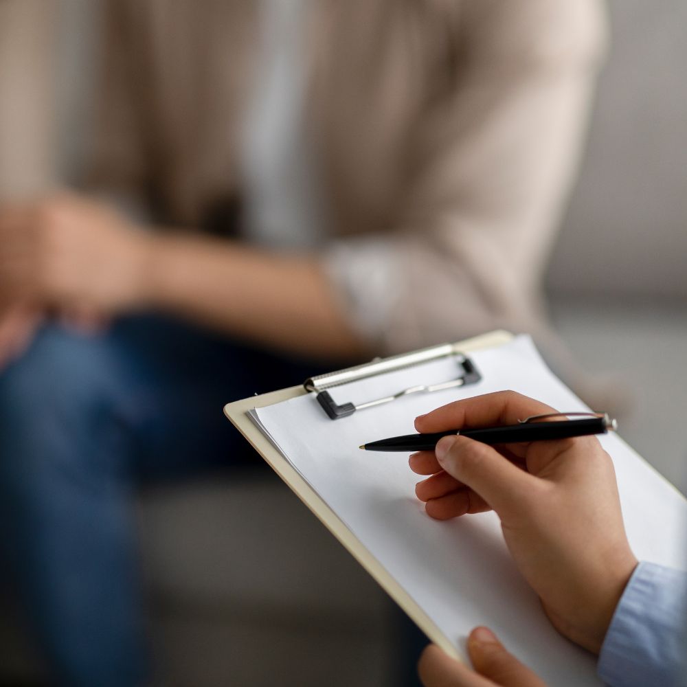 Therapist writing notes during client counseling session