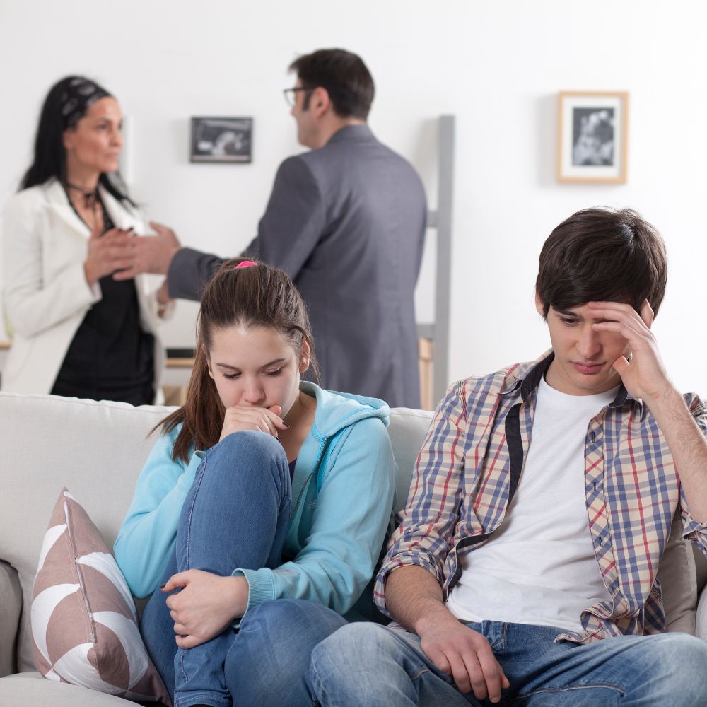 Teens upset while parents argue in background
