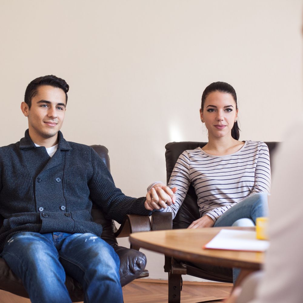 Calm couple holding hands during counseling session