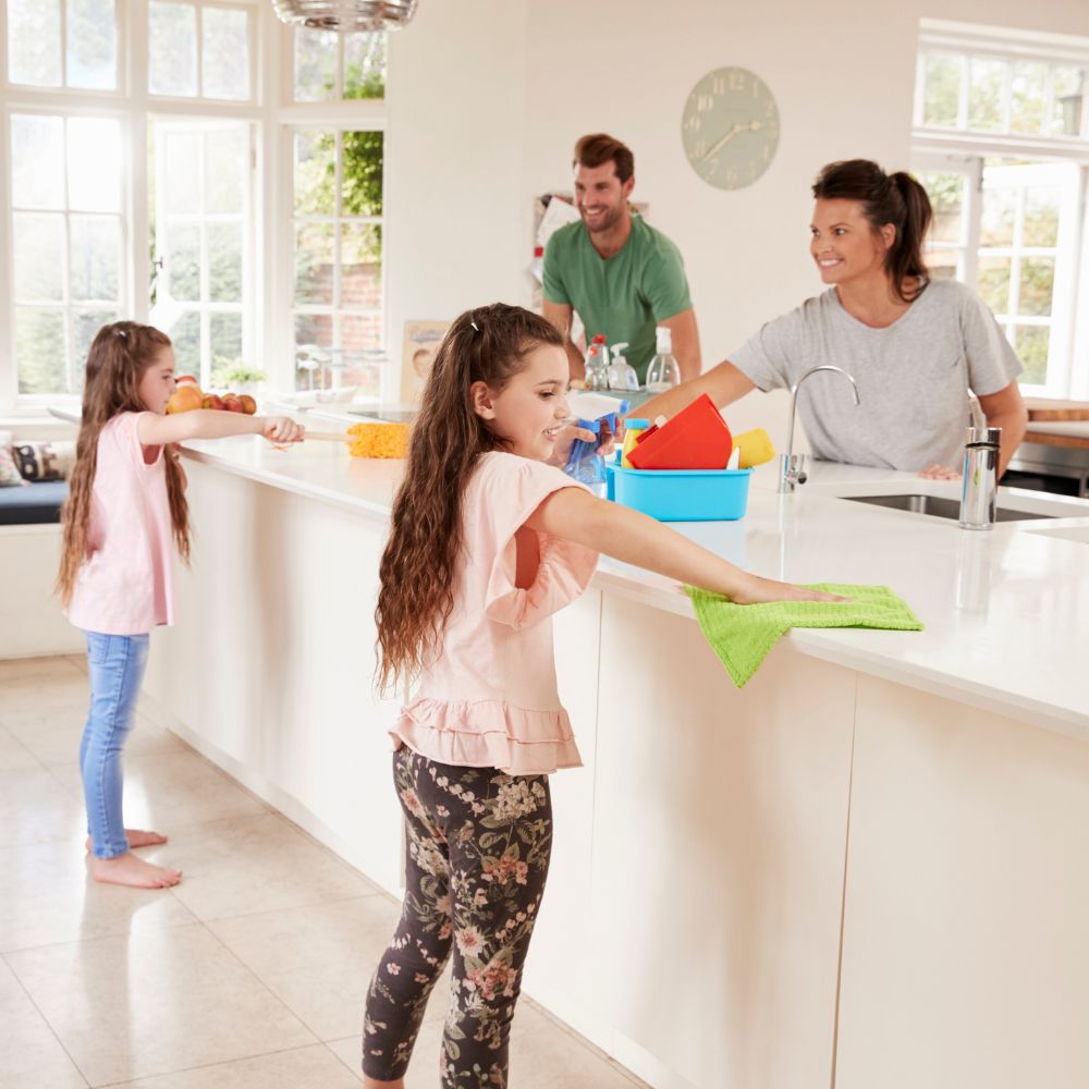 Family happily cleaning kitchen together