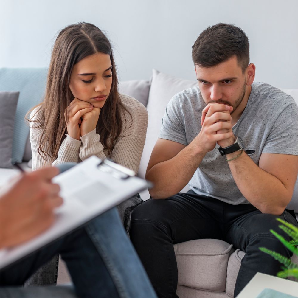 Worried couple listening attentively during counseling appointment