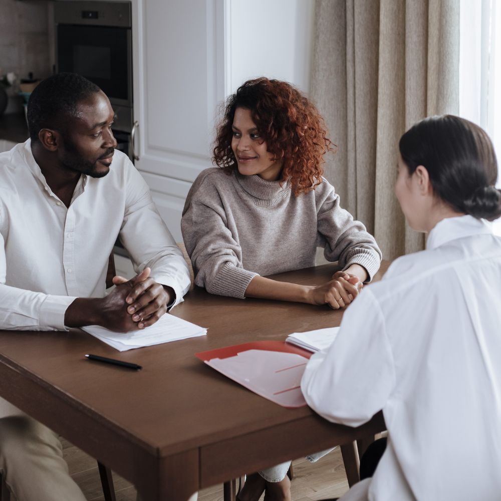 Couple talking with counselor while sitting on leather couch