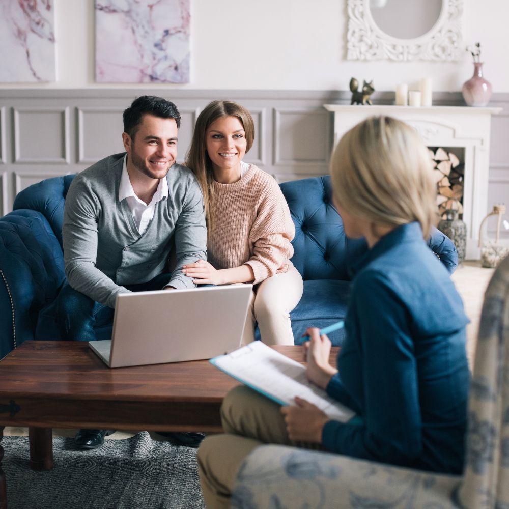 Smiling couple talking with counselor in cozy office
