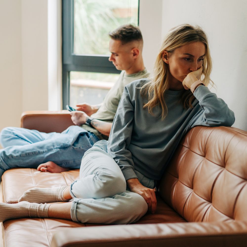 Couple sitting apart looking upset and distant