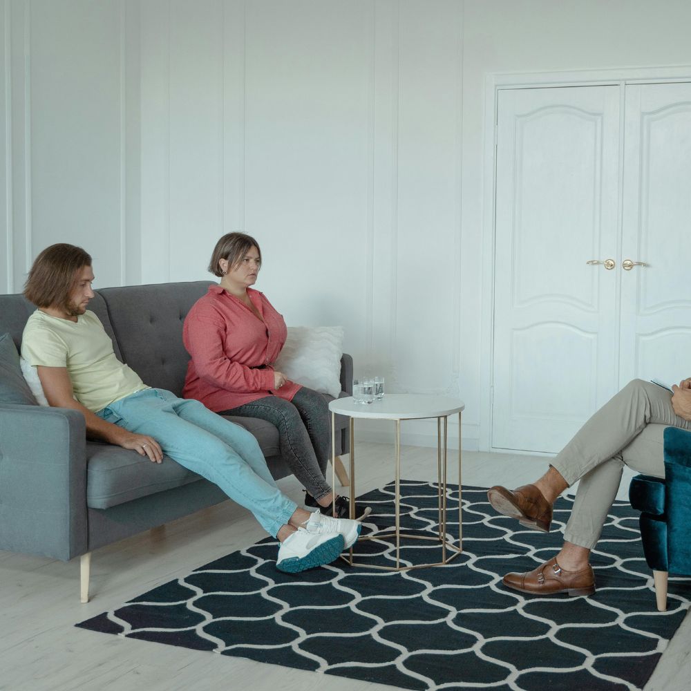 Man and woman sitting apart during tense counseling