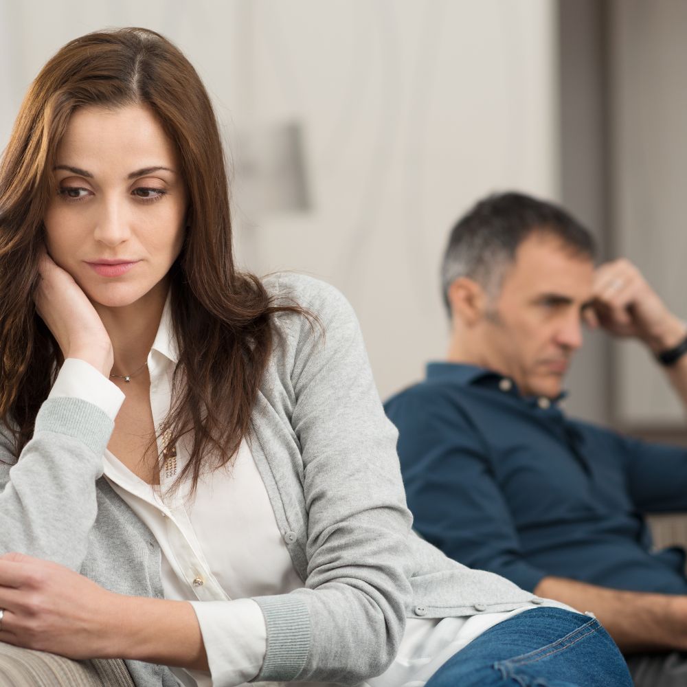 Sad woman with man sitting in background