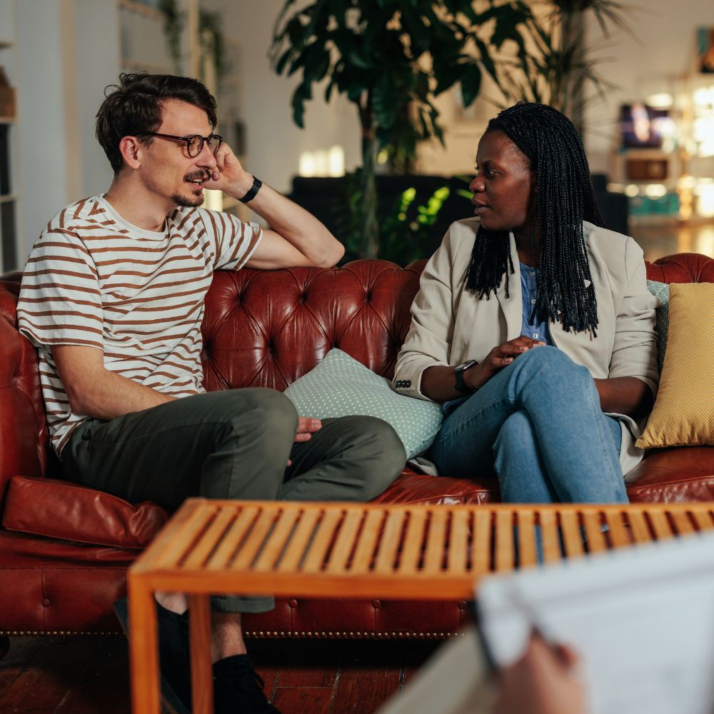 Smiling couple meeting with relationship coach