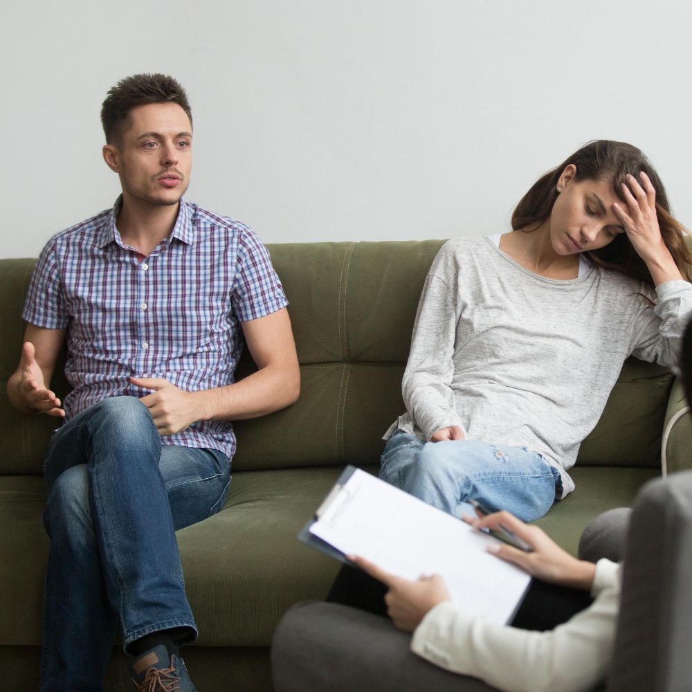 Man speaking while woman looks stressed during counseling