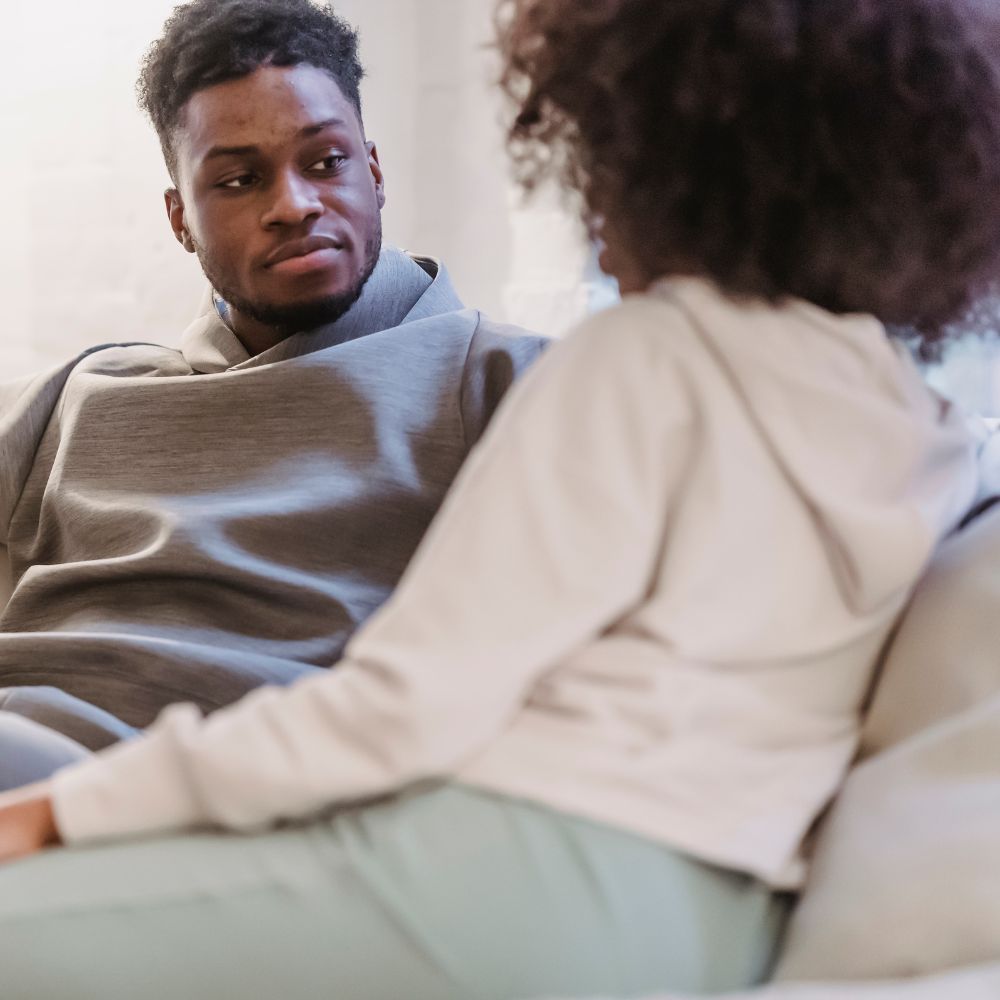 Couple sitting close on couch having a serious conversation