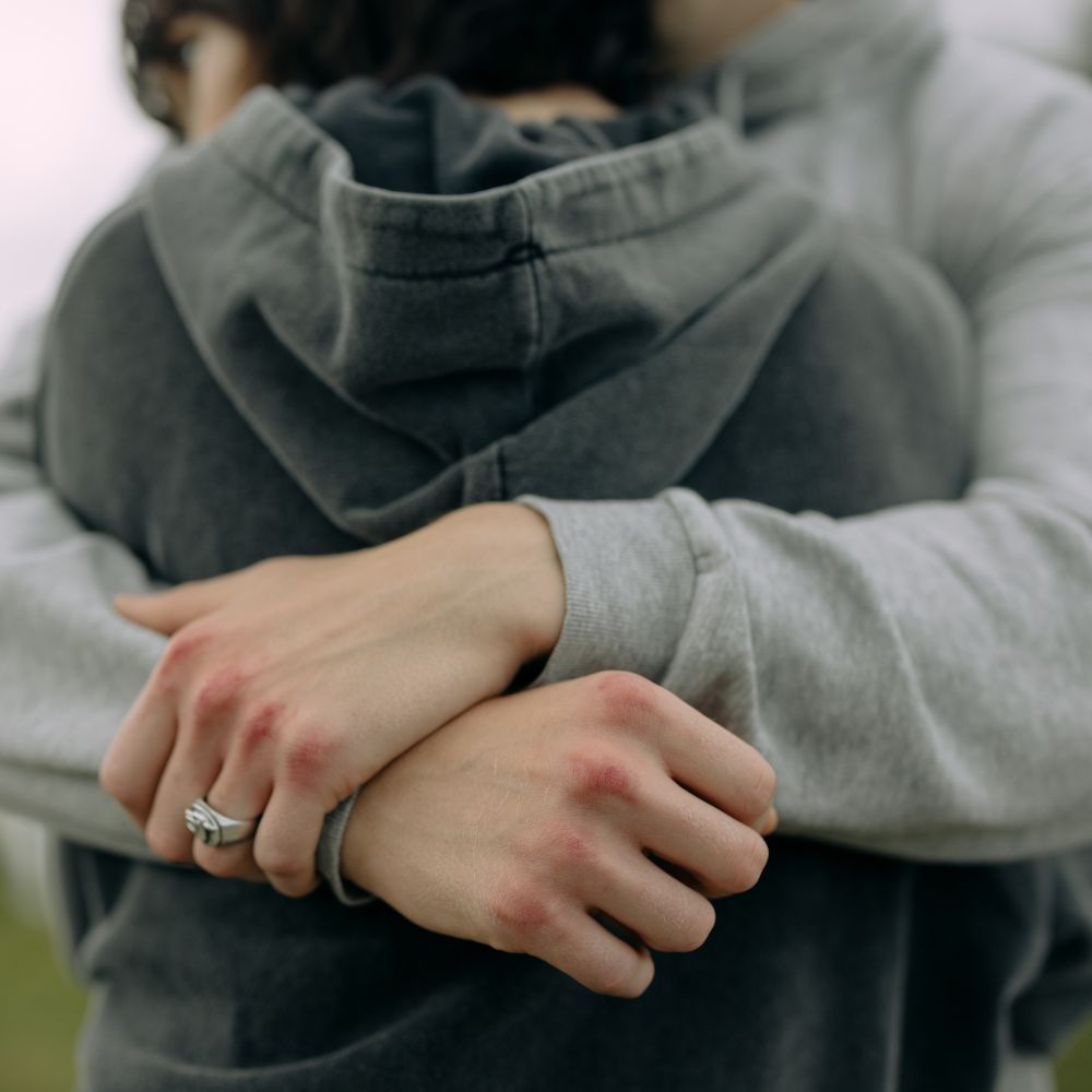 Couple tightly hugging and dressed warmly showing support and comfort