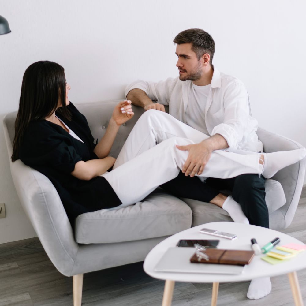 Couple sitting on sofa engaged in relaxed and intimate conversation